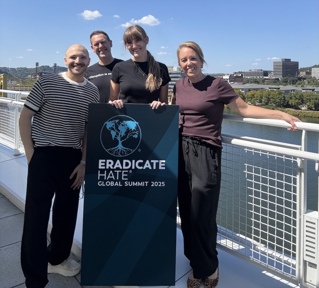 TrailBlaze team standing by Eradicate Hate Global Summit sign